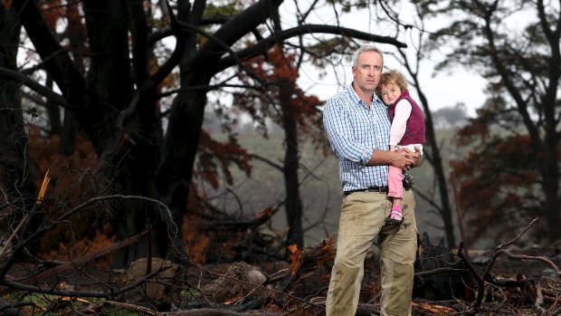 Matthew Cleve with his daughter Maggie after fire ravaged his farm in 2014.