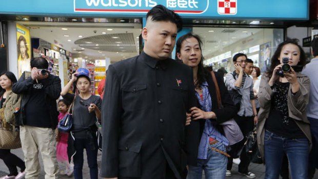Howard, dressed as Kim Jong Un supreme leader of North Korea, poses with a tourist in Hong Kong.