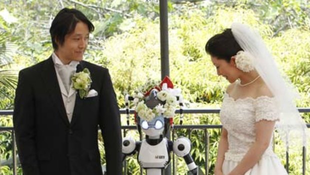 Tomohiro Shibata (left) and Satoko Inoue marry with 'I-Fairy' officiating.