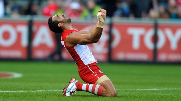 Father's pride: Adam Goodes tastes premiership glory as the Sydney Swans down the Hawthorn Hawks in last year's grand final.