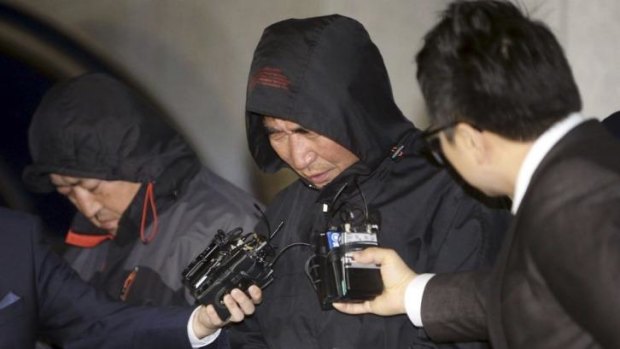 Under arrest: the ferry Sewol's captain, Lee Joon-seok, 69, runs the media gauntlet after leaving court in Mokpo, south of Seoul, on Saturday. 