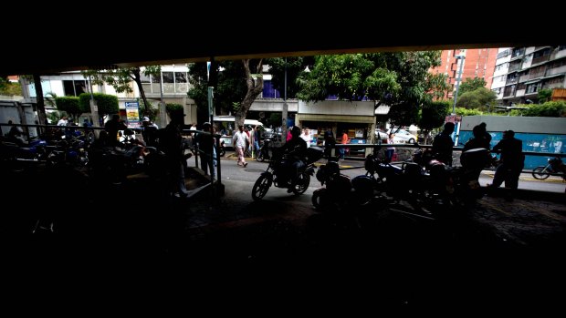 Mto-taxi drivers wait for clients at their station near the site where Roberto Bernal was beaten and burned alive.