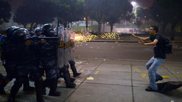 In the line of fire: A demonstrator is shot by rubber bullets after clashes erupted during a protest in Rio de Janeiro.