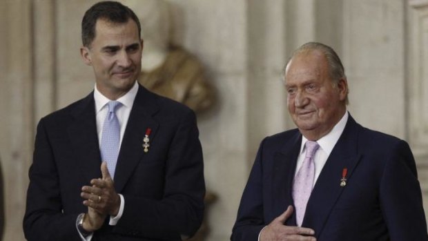 A tearful King Juan Carlos stands next to his son Crown Prince Felipe during the signature ceremony. 