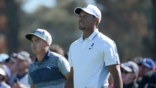 Tiger Woods (right) watches his tee shot on the 10th hole during the first round of the Farmers Insurance Open at Torrey Pines Golf.