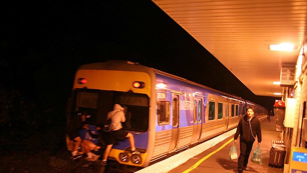 Three people cling to the back of a moving train at Hughesdale station overnight.