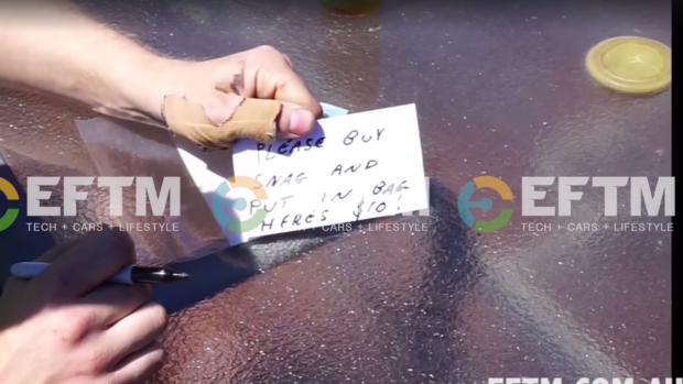 A note in the video reading "please buy snag and put in bag, here's $10".