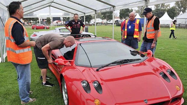 Albert Park staff yesterday try to retrieve the keys from the AJF1 supercar after locking them inside.
