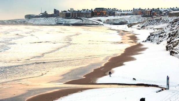 A man walks his dog on Tynemouth beach, north eastern England as Britain shivered in record low temperatures.