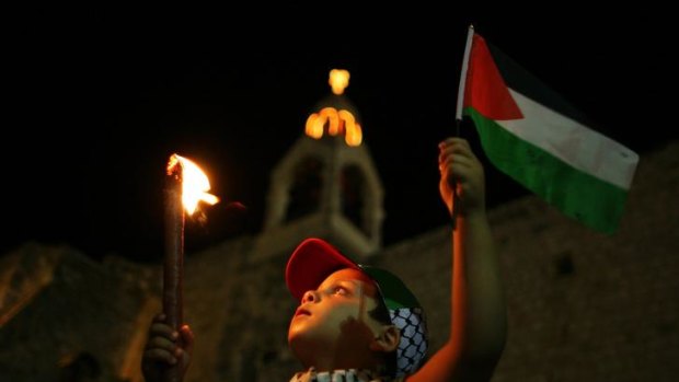 A Palestinian child takes part in a candle light rally to show support for the Palestinian bid for full United Nations membership this month, outside the Church of the Nativity, in the West Bank town of Bethlehem, .X IMAGES OF THE DAY)