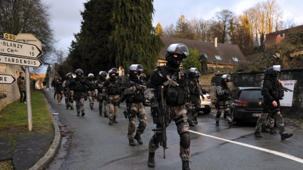 Manhunt: French police special forces on patrol in Corcy in northern France.