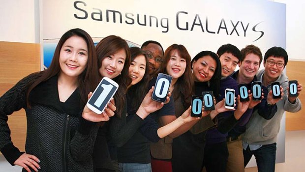 100 million ... Samsung employees show off the number on Galaxy S smartphone displays.