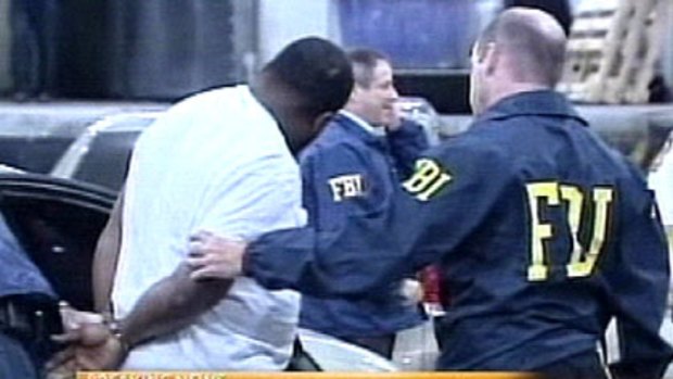 An FBI agent escorts a man arrested after an alleged terrorist plot was uncovered in New York.