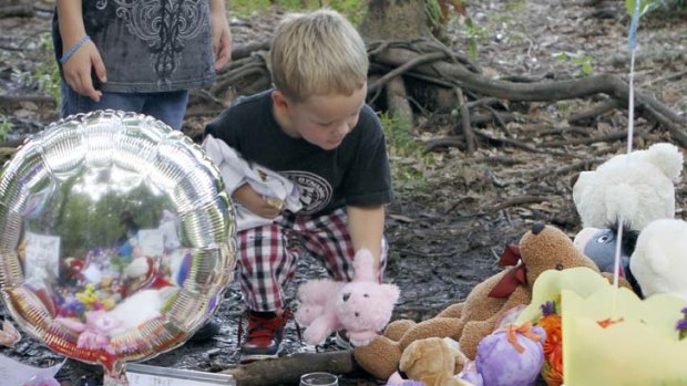 Yadiel Perez, 3, of Kissimmee, Florida, places a teddy bear at a memorial to Caylee Anthony  in Orlando.