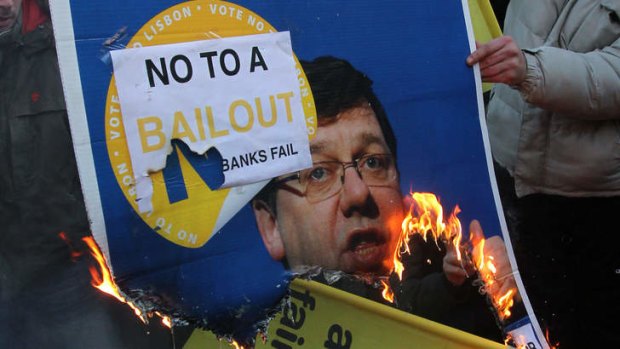 Protesters burn a placard of Brian Cowen, the former Irish Prime Minister, in 2010.