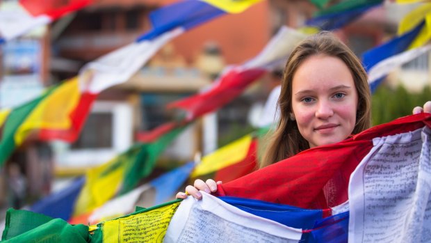 Cultural encounter: A teenager with Buddhist prayer flags in Nepal.