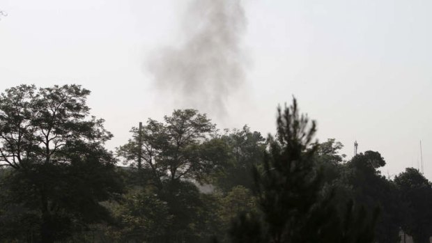 Smoke rises from the eastern gate of the presidential palace in Kabul, Afghanistan, Tuesday June 25, 2013. The Taliban said they have hit one of the most secure areas of the Afghan capital with a suicide attack, as a series of explosions rocked the gate leading into the presidential palace.
