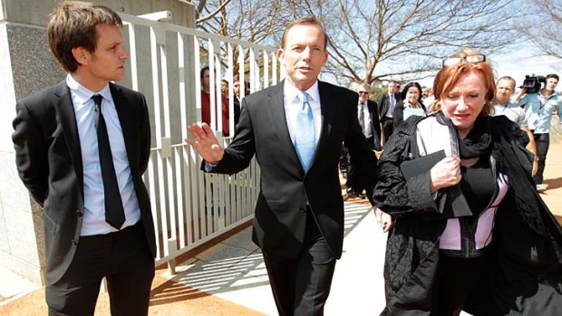 Not amused ... The Chaser's Craig Reucassel, left, attempts to interview Tony Abbott yesterday.