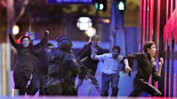 Hostages run from the Lindt Cafe siege in December 2014.