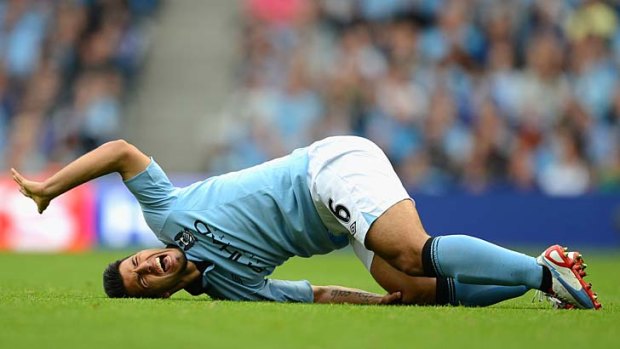 Distress signal ... Sergio Aguero grimaces in pain with a knee injury that may figure in the shape of City's title defence.