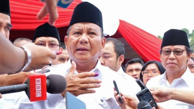 Indonesian presidential candidate Prabowo Subianto speaks to the media after voting on Wednesday. He and his rival Joko Widodo have claimed victory.