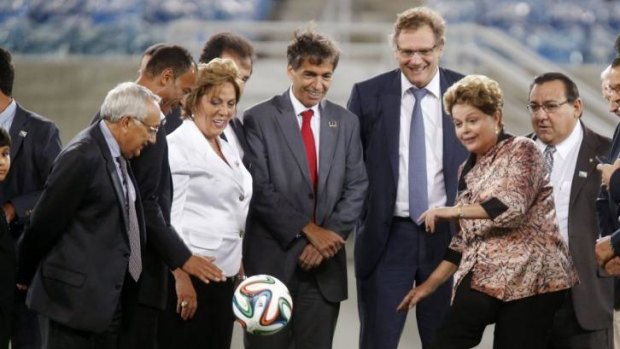 Brazil's President Dilma Rousseff (2nd R) kicks a ball next to FIFA Secretary General Jerome Valcke (3rd R) during the opening ceremony of the Arena das Dunas stadium.