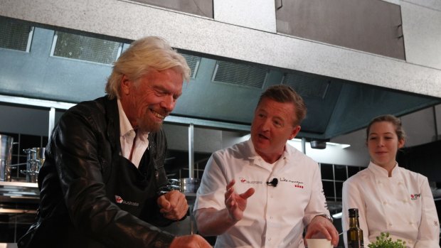 Richard Branson (L) gets a lessson from Luke Mangan on how to make meals look good.