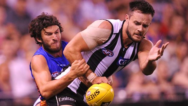 Claws on: Lion Rohan Bewick wraps up Collingwood defender Nathan Brown.