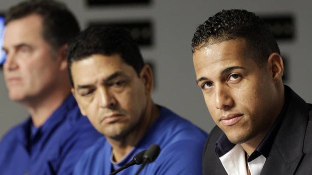 Suspended ...Toronto Blue Jays' Yunel Escobar, right, appears alongside manager John Farrell, left, and coach Luis Rivera, centre, at a news conference.