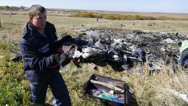 An Emergencies Ministry member walks near belongings and wreckage at the site where the downed Malaysia Airlines flight MH17 crashed on July 17, in Donetsk region, eastern Ukraine.