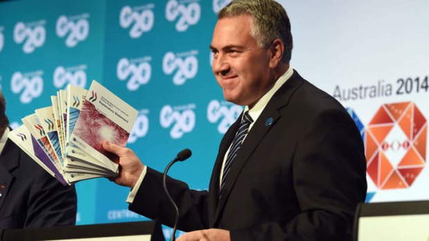 Optimistic: Treasurer Joe Hockey  holds up a report during a press conference at the G20 Finance Ministers and Central Bank Governors Meeting in Cairns on Saturday.