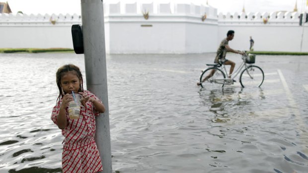 A girl in a flooded street outside the Grand Palace in Bangkok.