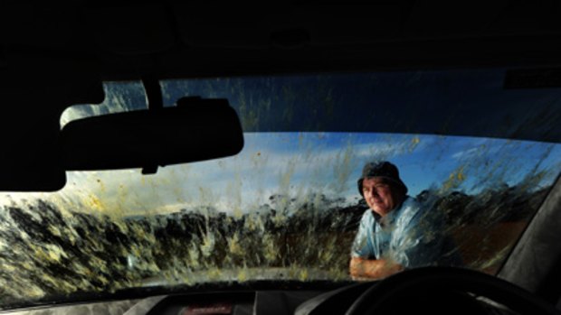 Blurred vision... Mildura farmer Colin Hunt peers through his locust-splattered windscreen in April.