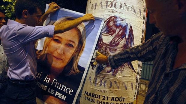 Backlash ... French far-right National Front activists prepare to cover up a Madonna poster with a poster of their leader.