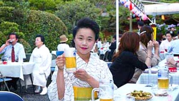 A geisha enjoys a cold beer in Kyoto's new geisha beer garden.