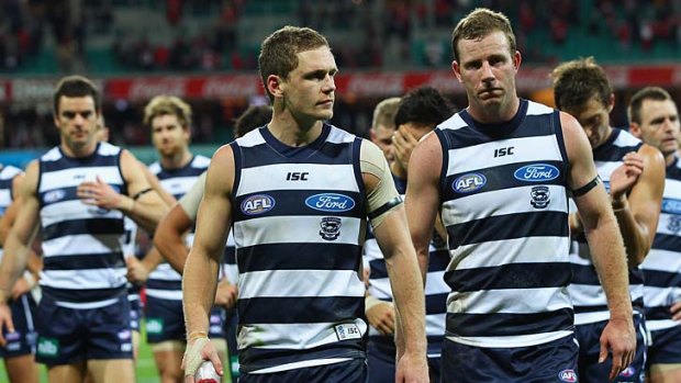 Glum Geelong players return to the dressing room after being beaten by the Swans.