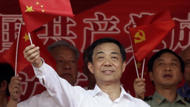 Showing the way: Bo Xilai waves the Chinese flag in a show of nationalism.