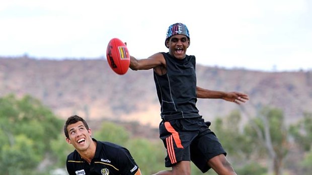 Launching pad: Shanley Malbunka uses Richmond's Alex Rance for "speccy" practice during the Tigers' visit to Centralian College in Alice Springs.