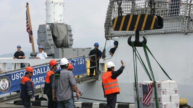 Georgian port workers and US sailors unload humanitarian aid from the US Coast Guard Cutter Dallas in the Black Sea.