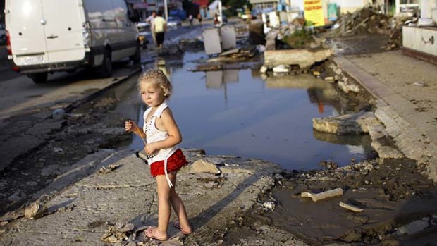 A girl walks along a flooded street in Krimsk, about 1,200km south of Moscow.