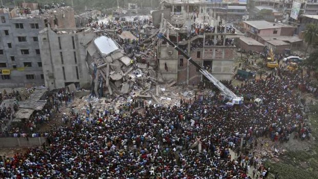 Desperate wait: Bangladeshis watch the rescue operations at the doomed factory.