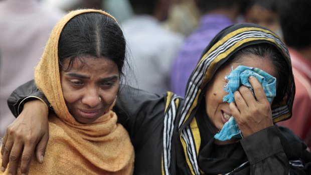 Bangladeshi people cry as rescuers search the River Padma after a passenger ferry sank after colliding with a cargo boat. 