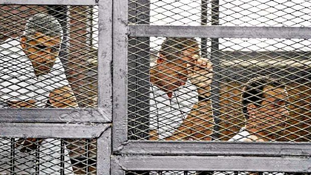 Al-Jazeera's Mohammed Fahmy, Peter Greste and Baher Mohamed appear in a defendant's cage during their trial in May.