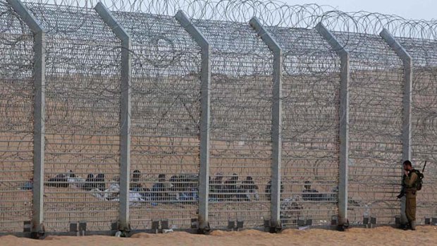 On guard ... a guard stands at the border fence between Israel and Egypt.