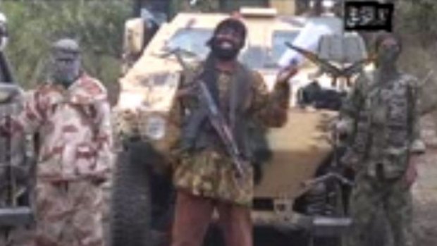 A still from a video that shows the leader of the Islamist extremist group Boko Haram Abubakar Shekau (centre) threatening to sell hundreds of girls his group abducted from a Chibok school in the northern state of Borno.