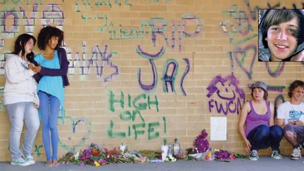 Sadness and anger ... students from Mullumbimby High School yesterday with floral and graffiti tributes to their 15-year-old schoolmate, Jai Drummond-Morcom (inset), who died after a fight. 