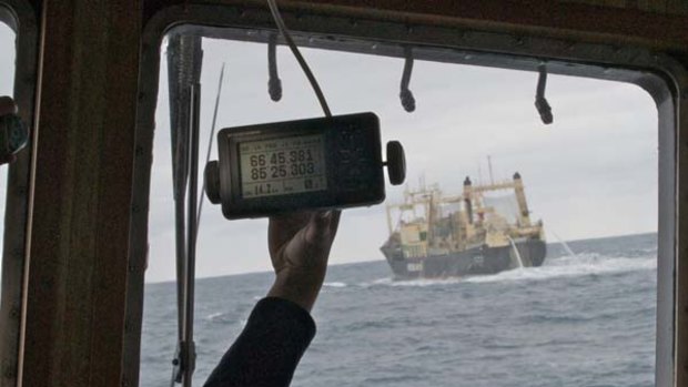 The Nisshin Maru enters the Chilean claimed Antarctic Zone with the Bob Barker  on her tail. A crew member holds up a device confirming the factory ship's location..