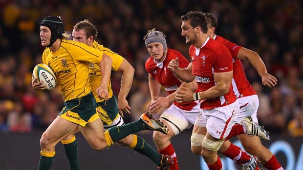 Catch me if you can: Wallaby Berrick Barnes makes a break and leads a chasing pack last night.