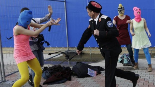 A Cossack militiaman attacks Tolokonnikova and a photographer.