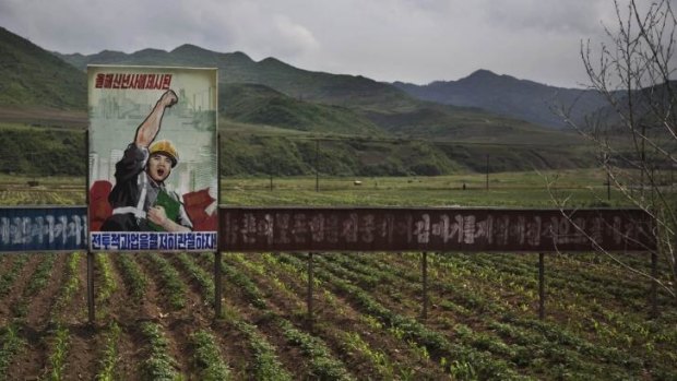 A propaganda billboard stands in a field south of Samsu, in North Korea's Ryanggang province.